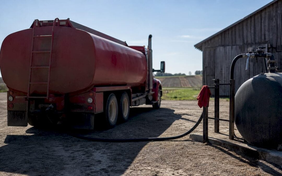 Fuel delivery specialist disconnecting hose at farm tank