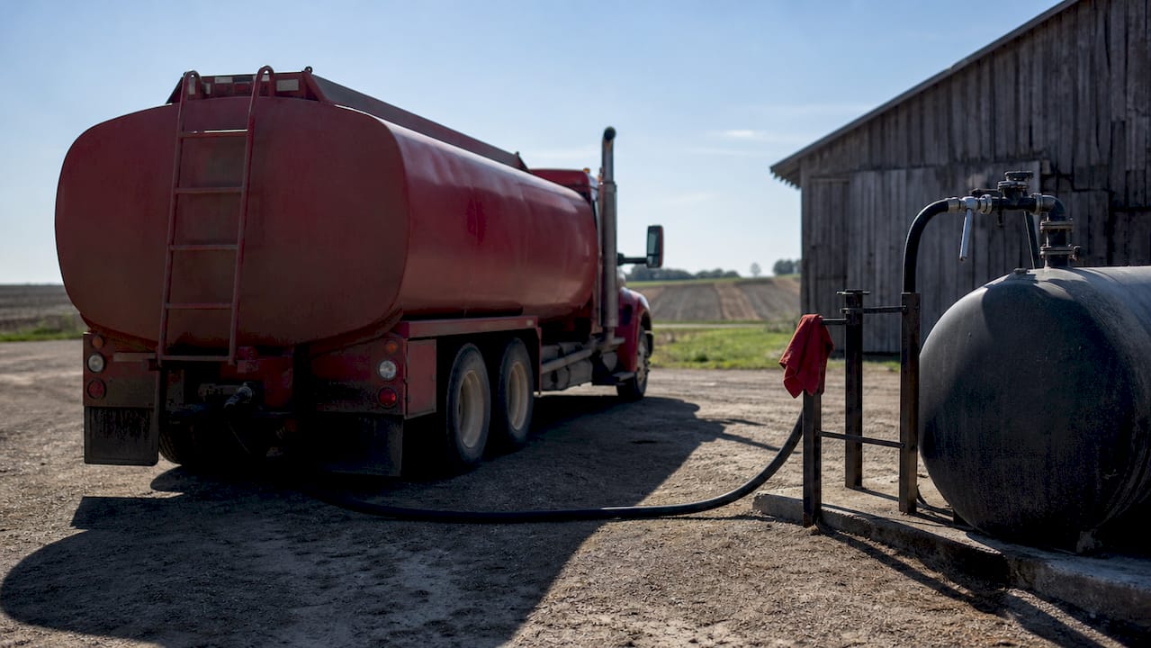 Fuel delivery specialist disconnecting hose at farm tank