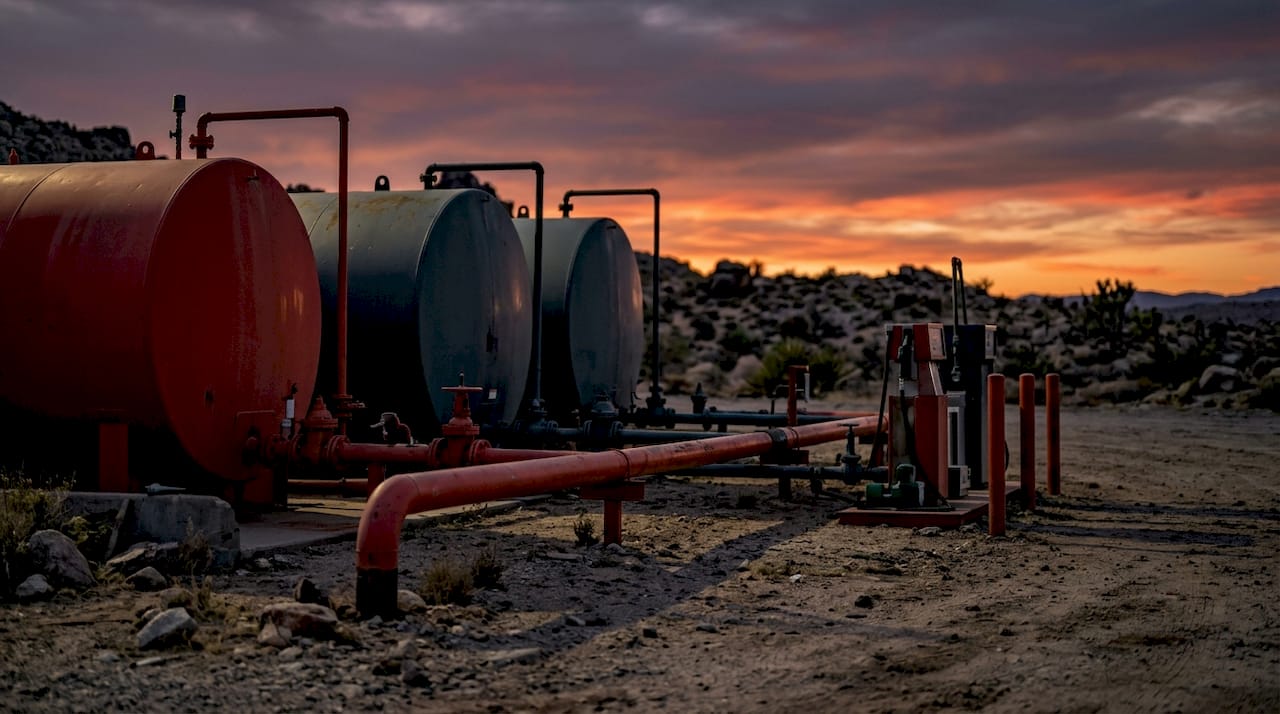 Remote oil field fuel storage tanks at dawn
