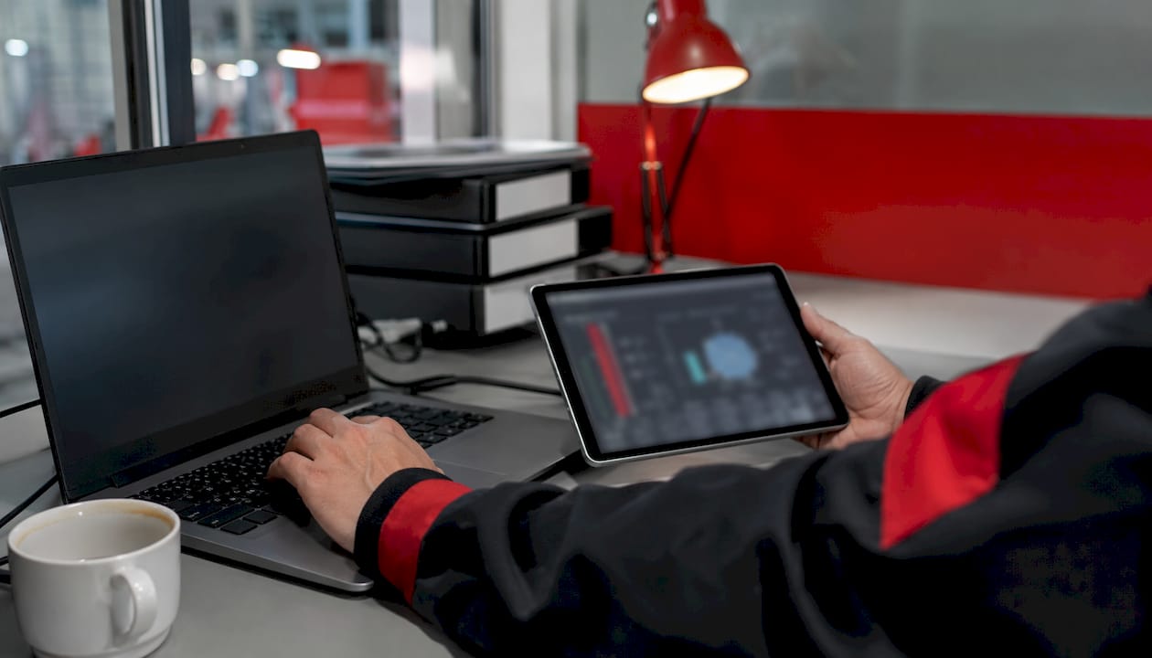 Hands on laptop and tablet monitoring fuel telemetry