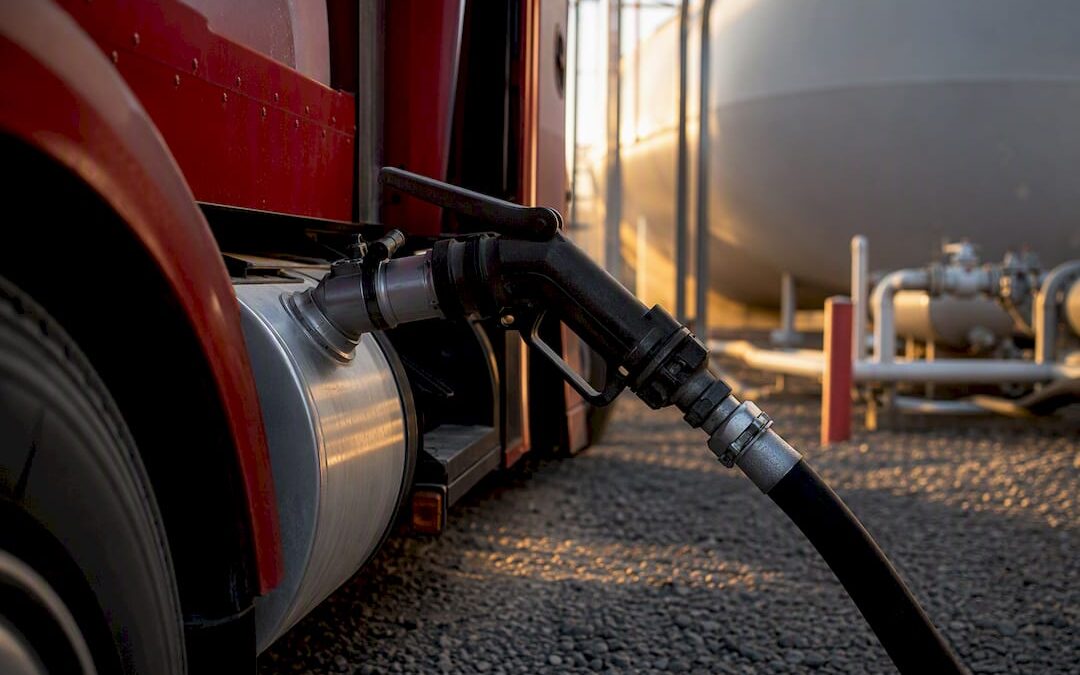 Close-up of red dye diesel fuel delivery nozzle connected to tank