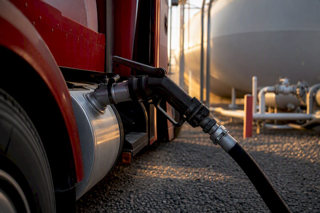Close-up of red dye diesel fuel delivery nozzle connected to tank