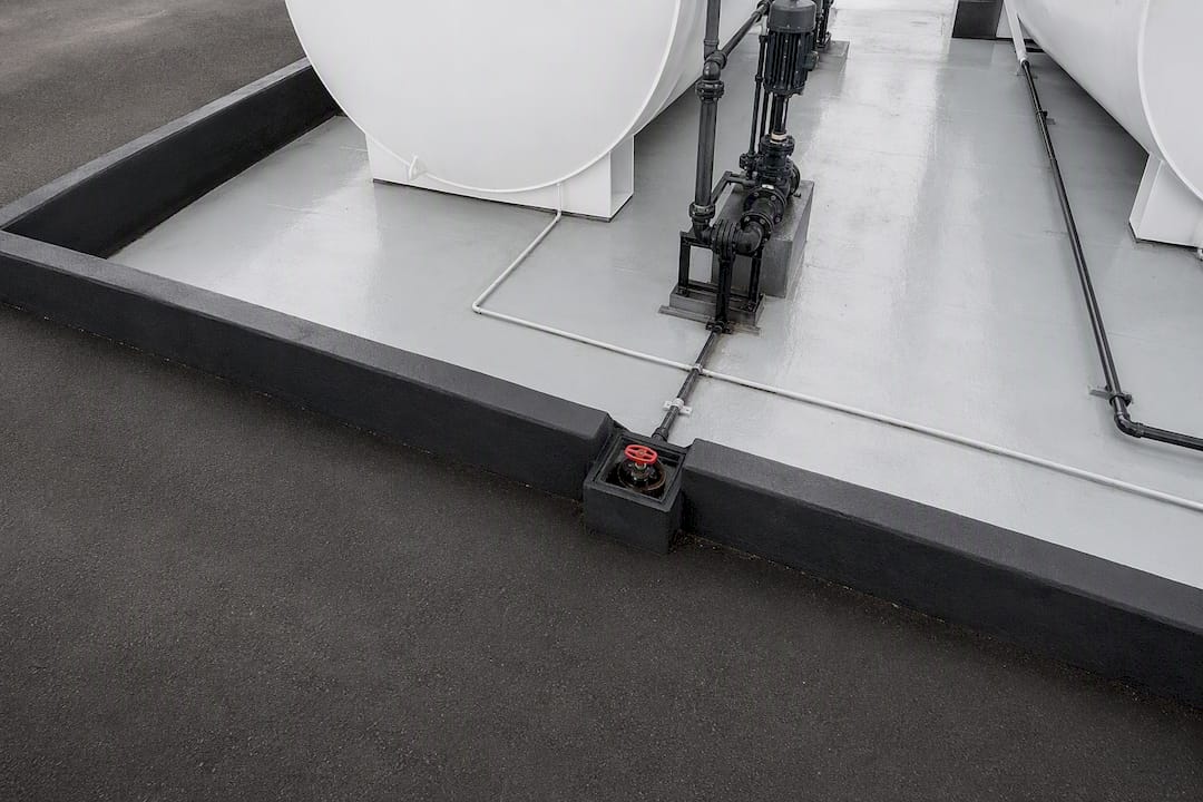 Berm and sealed drain on containment pad