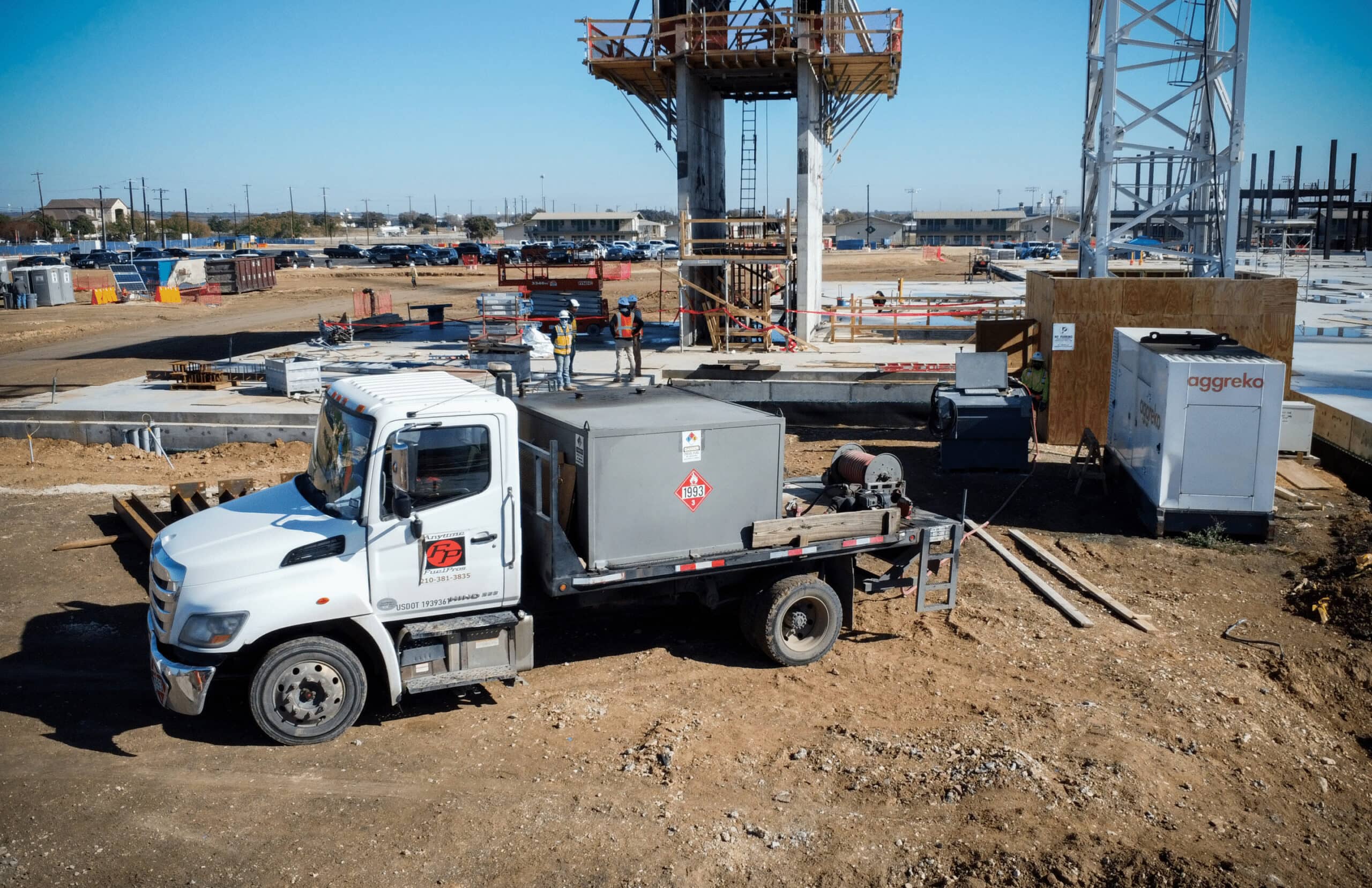 On-site fuel delivery truck providing fuel to construction equipment at a busy job site.